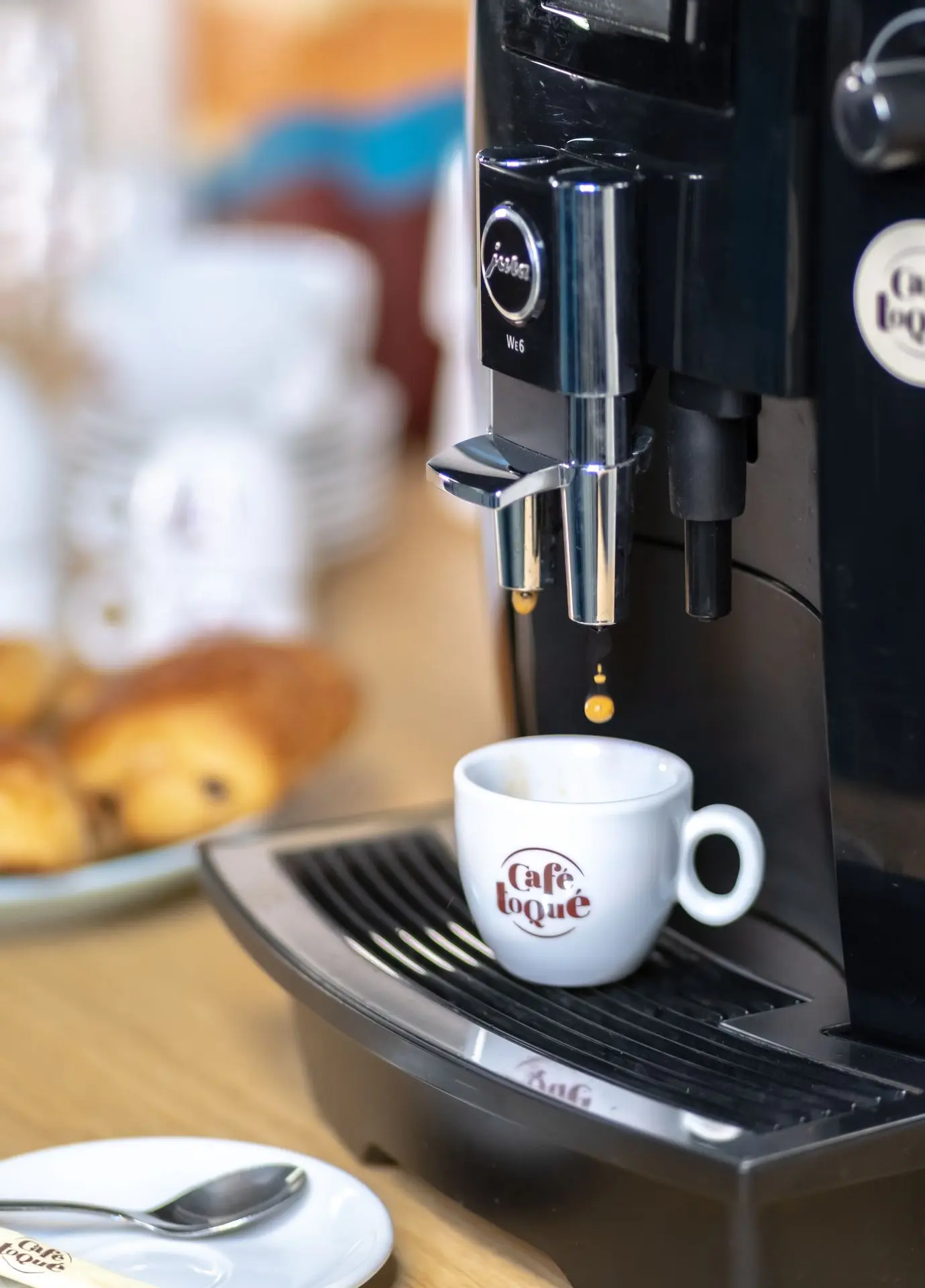 Café s'écoulant d'une machien automatique Jura WE6 dans une tasse café toqué